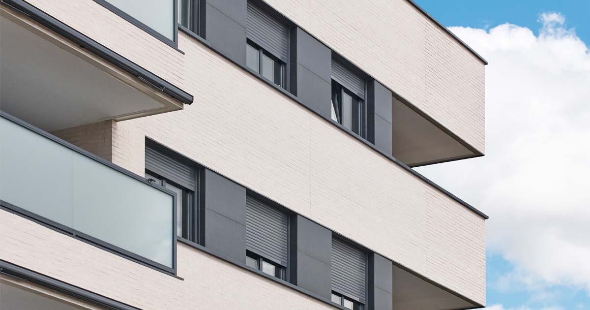 Close up angled image of an apartment building with balcony.